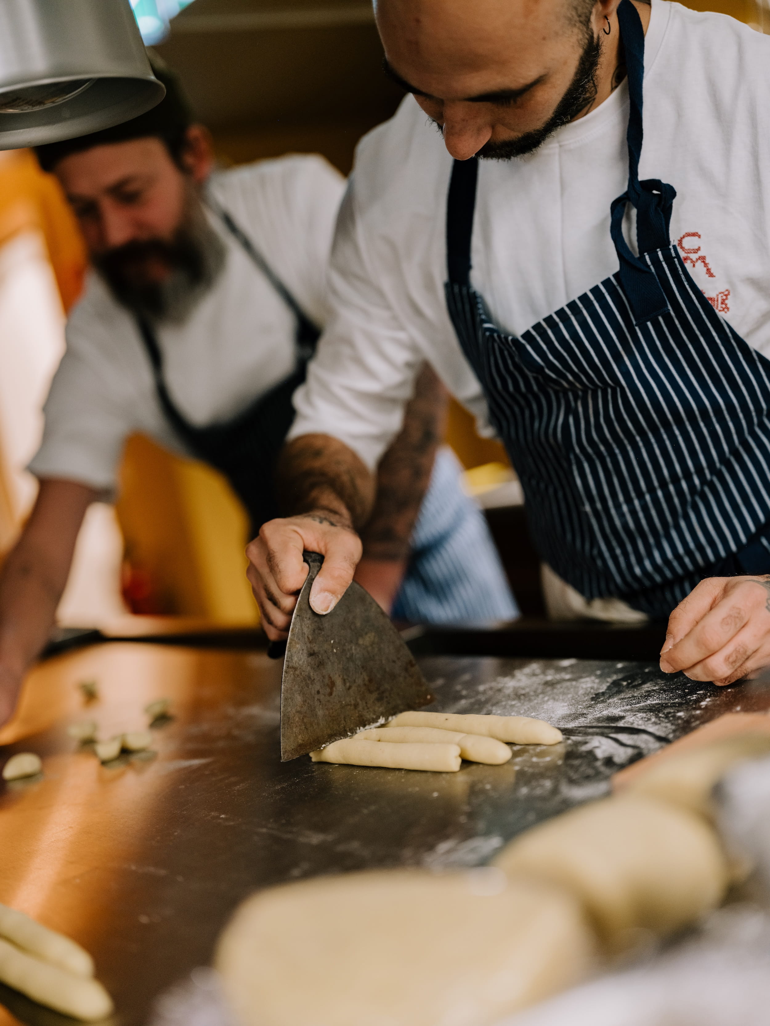 Chefs cutting gnocchi dough in the kitchen
